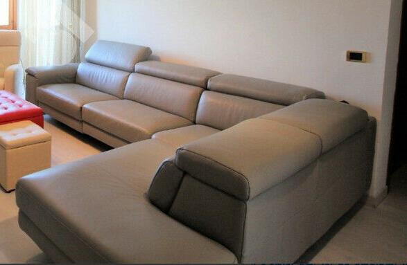 divano angolare in pelle grigio chiaro con